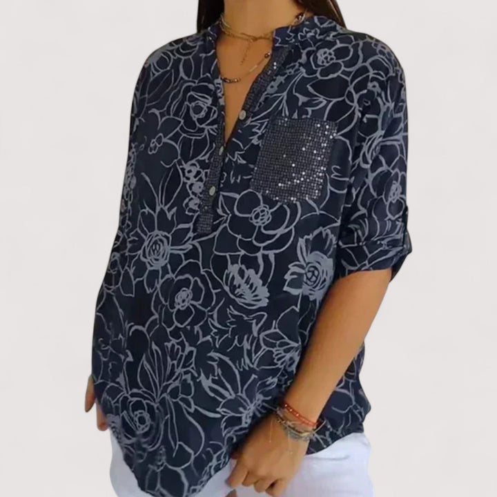 Detail des leichten, luftigen Stoffes der Damen Blumenbluse mit vibrantem Blumenmuster für den Sommer.