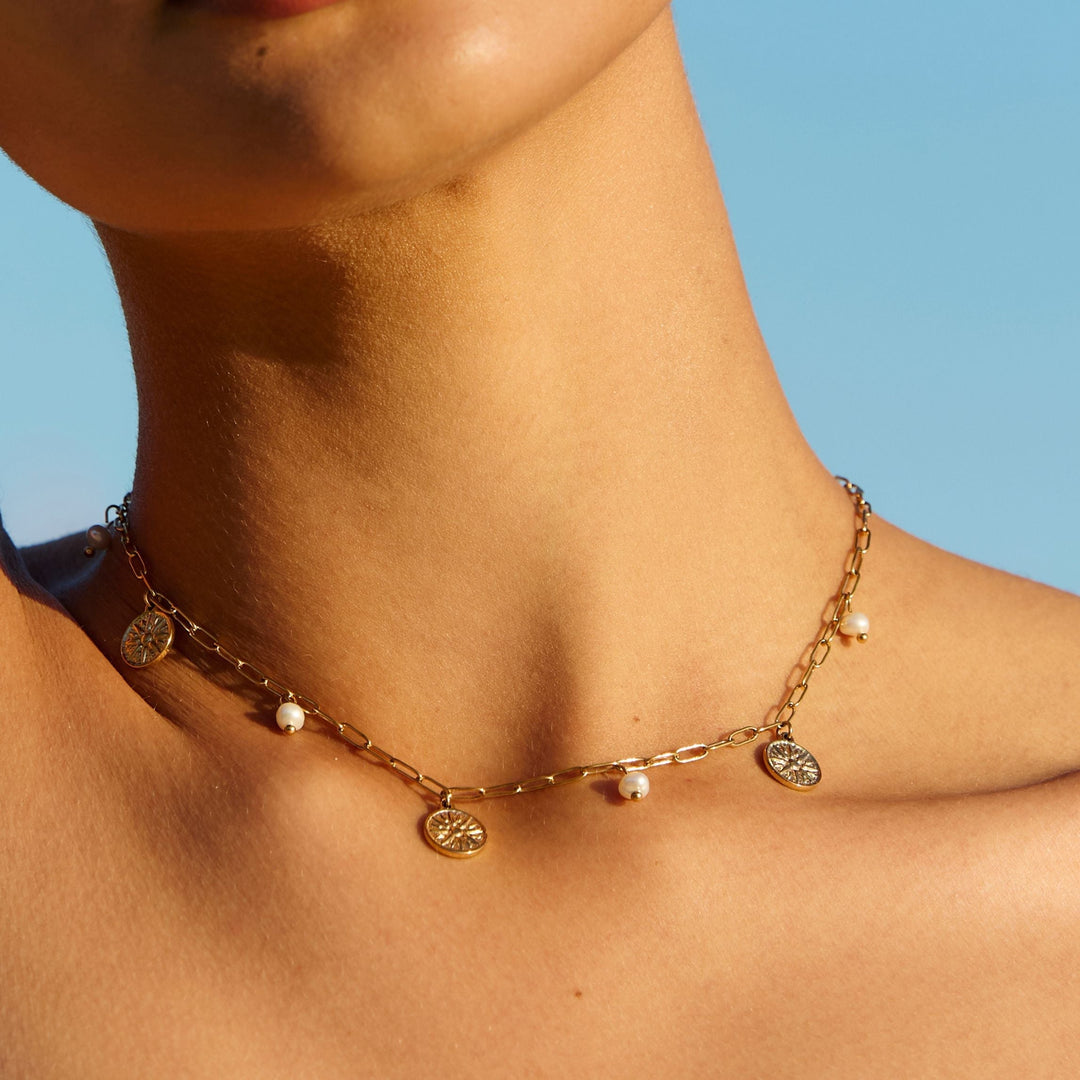 Detailansicht: Goldener Sonnen-Anhänger und schimmernde Süßwasserperlen am Damen Choker. Hochwertiger Schmuck.