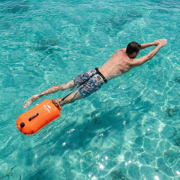 Leuchtend neonpinke Schwimm-Boje mit Staufach. Erhöht Sicherheit & Sichtbarkeit im Freiwasser.