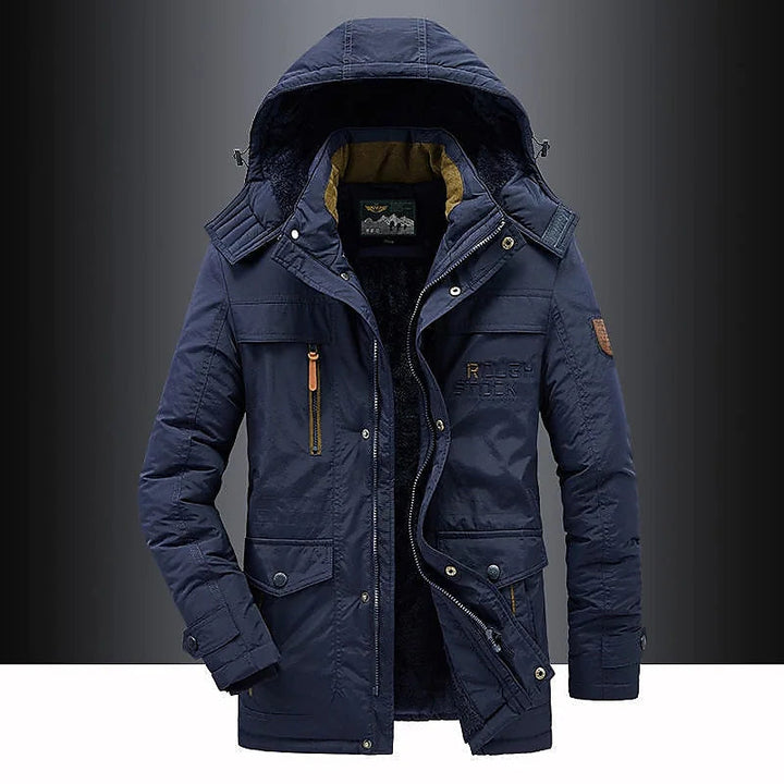 Mann trägt winddichten Herren-Parka Leventis mit Fleece-Futter beim Outdoor-Spaziergang im Winter. Warme Winterjacke.